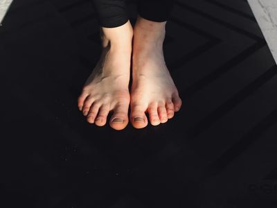 Feet on a yoga mat performing a balance pose