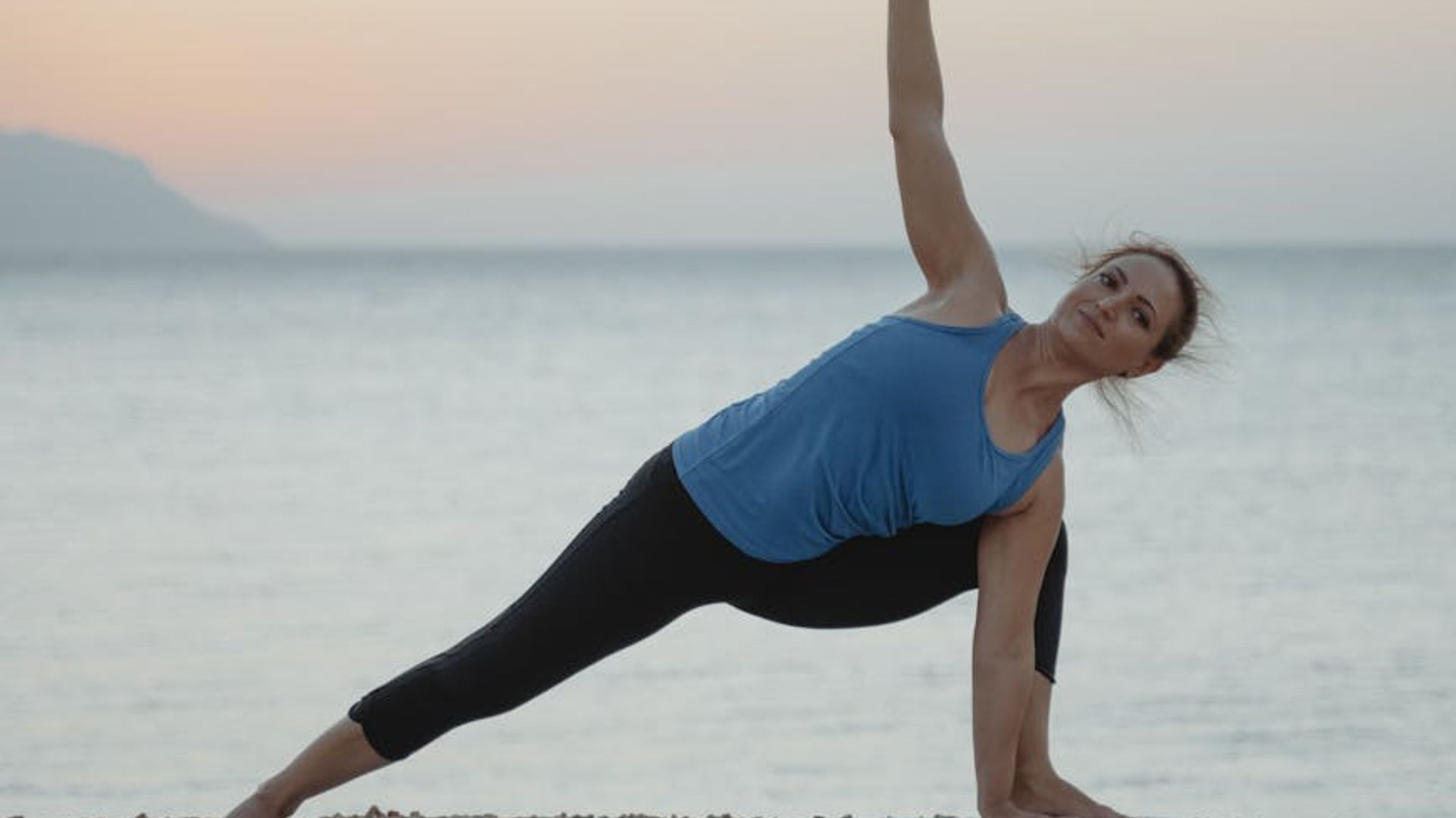 Person doing yoga in a bright studio with morning sun